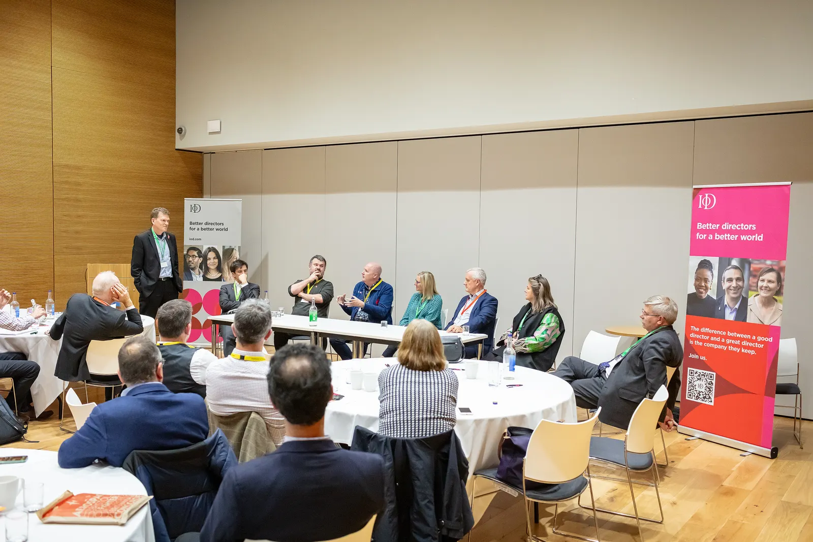 Craig Fearn on a panel at an Institute of Directors event, with an audience seated at tables