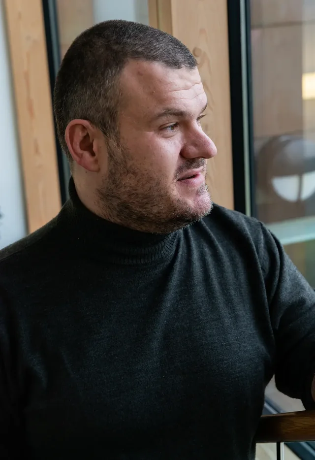 Craig Fearn photographed beside a window, looking away from the camera, mid-thought